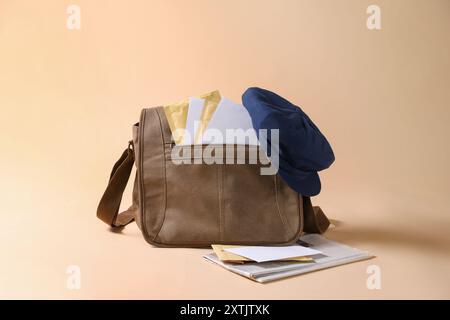 Braune Brieftasche, Briefumschläge, Zeitungen und Hut auf beigefarbenem Hintergrund Stockfoto