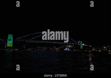 Sydneys Wahrzeichen, die Harbour Bridge, beleuchtet mit farbigen lazar-Lichtern und Aborigines-Kunstbanner, die an den Brückensäulen hängen, nahmen an der A Teil Stockfoto