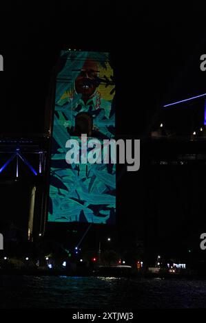 Sydneys Wahrzeichen der Harbour Bridge Säulen mit Aborigines-Kunst, die im Rahmen des jährlichen Vivid Sydney Festivs mit farbigen lazar-Lichtern beleuchtet wird Stockfoto