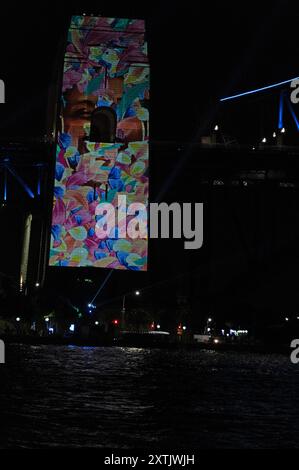 Sydneys Wahrzeichen der Harbour Bridge Säulen mit Aborigines-Kunst, die im Rahmen des jährlichen Vivid Sydney Festivs mit farbigen lazar-Lichtern beleuchtet wird Stockfoto