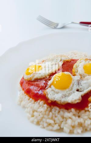 Reis mit Tomatensoße und gebratenen Wachteleiern. Schließen Sie die Ansicht. Stockfoto