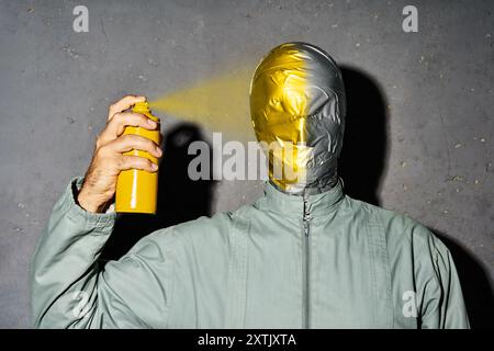 Mystery Crazy man mit Klebeband Gesicht malt sein Gesicht mit Sprühdose Stockfoto