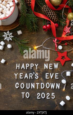 Winter, weihnachtsbeleuchtung, gemütliche Tasse heiße Schokolade Getränk mit Marshmallow auf hölzernem Tischhintergrund. Ansicht von oben mit englischem Text Happy New Year's Stockfoto