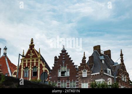 Historische Architektur in Rotterdam im Stadtteil Delfshaven. Rotterdam, Niederlande - 9. Juli 2024: Historische Architektur, Gebäude in Rotterdam im Bezirk Delfshaven der Niederlande. Blick auf den alten filigranen Ziegeldach-Fachwerkstuhl im historischen Stil verschiedener Häuser. Edit netherlands rotterdam delfshaven B97A6914 Stockfoto