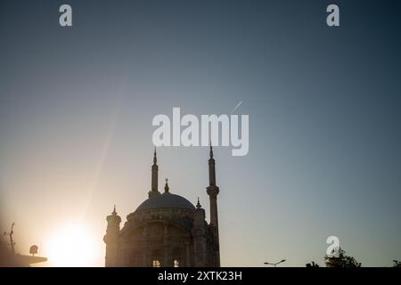 Ein atemberaubender Blick auf die Ortaköy-Moschee in den warmen Farben des Sonnenuntergangs, mit dem Bosporus und der Fatih-Sultan-Mehmet-Brücke im Hintergrund, Show Stockfoto