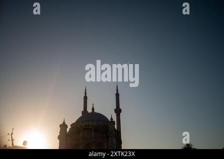 Ein atemberaubender Blick auf die Ortaköy-Moschee in den warmen Farben des Sonnenuntergangs, mit dem Bosporus und der Fatih-Sultan-Mehmet-Brücke im Hintergrund, Show Stockfoto