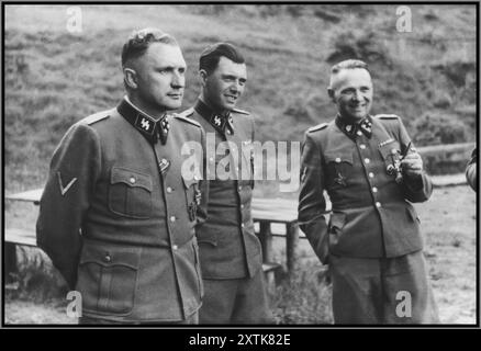 Auf dem Gelände des SS-Rückzugs von Solahuette vor dem Konzentrationslager Auschwitz von links nach rechts treffen sich drei SS-Offiziere: Richard Bär (Kommandant von Auschwitz), Dr. Josef Mengele und Rudolf Hoess (ehemaliger Kommandant von Auschwitz). Basierend auf den Offizieren, die Solahutte besuchten, wurden die Fotos zu Ehren von Rudolf Hoess aufgenommen, der seine Amtszeit als Garnisonkommandant beendete. 22. Juli 1944 - 29. Juli 1944 Solahutte, [Oberschlesien; Auschwitz] Polen Stockfoto