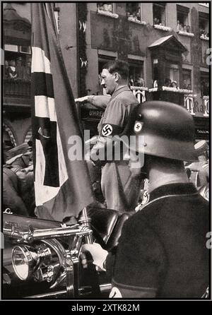 Adolf Hitler grüßt vorbeifahrende SA-Truppen beim sechsten Reichsparteitag in Nürnberg, der in seinem Mercedes-Wagen steht. Die Blutfahne aus dem Putsch von 1923 ist im Vordergrund abgebildet. Heinrich Hoffmann/Studio von H. Hoffmann 1934 September 04 - 1934 September 10 Nürnberg, [Bayern] Deutschland Nürnberg Stockfoto