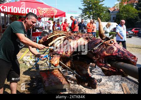 Zagreb, Kroatien. August 2024. Händler schnitzen ein Stück aus Spieß gebratenem Ochsen während eines Festes der Himmelfahrt der Heiligen Jungfrau Maria in Zagreb, Kroatien am 15. August 2024. Foto: Emica Elvedji/PIXSELL Credit: Pixsell/Alamy Live News Stockfoto