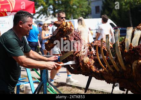 Zagreb, Kroatien. August 2024. Händler schnitzen ein Stück aus Spieß gebratenem Ochsen während eines Festes der Himmelfahrt der Heiligen Jungfrau Maria in Zagreb, Kroatien am 15. August 2024. Foto: Emica Elvedji/PIXSELL Credit: Pixsell/Alamy Live News Stockfoto