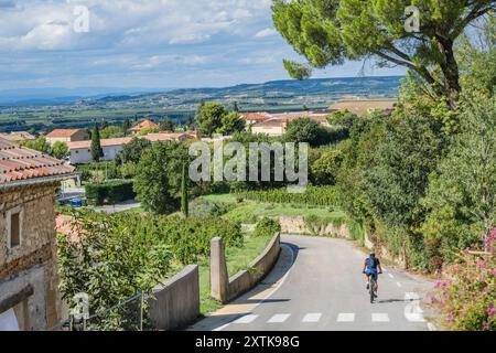 Männlicher Radfahrer, der die Gemeinde Boulbon im Département Bouches-du-Rhône in Südfrankreich verlässt. Stockfoto