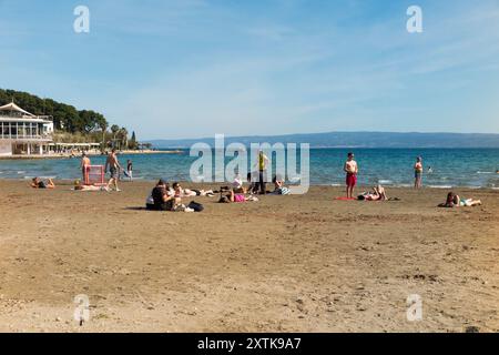 Sandiger, schöner Touristenstrand, der von Einheimischen und Touristen an einem heißen, sonnigen Tag mit blauem Himmel und Sonne genossen wird. Strand von Bacvice. Trennen. Kroatien. (138) Stockfoto