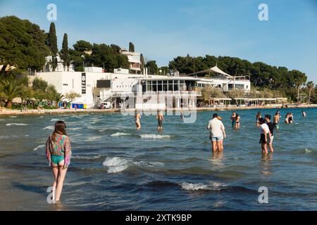 Sandiger, schöner Touristenstrand, der von Einheimischen und Touristen an einem heißen, sonnigen Tag mit blauem Himmel und Sonne genossen wird. Strand von Bacvice. Trennen. Kroatien. (138) Stockfoto