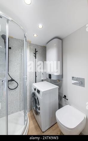Helles, elegantes, modernes Badezimmer Innendesign mit Dusche, weißem Waschbecken. Weiße Wände, Waschmaschine, LED-Lichter. Weitwinkel Stockfoto