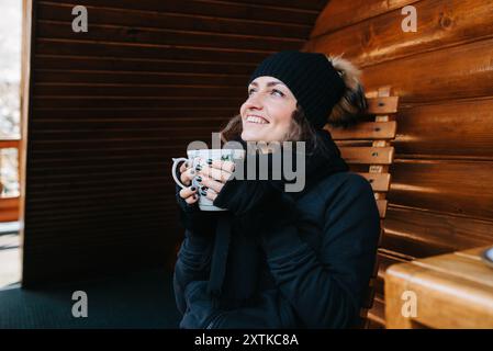 Mädchen auf der Veranda eines schneebedeckten Holzhauses in Die Winterberge Stockfoto