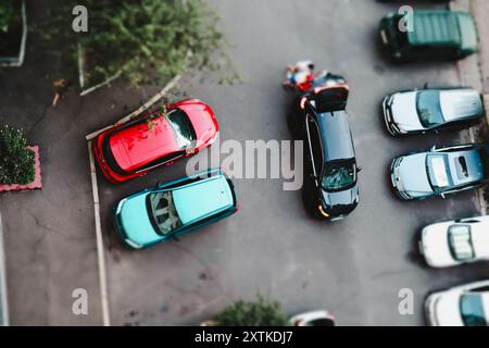 Kiew, Ukraine. 13. August 2024 Autos parkten auf einem Parkplatz im Innenhof eines Wohnhauses mit Blick von oben. Autos Dächer in einem Hof. Stockfoto