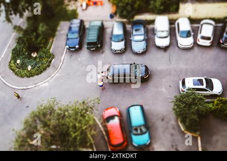 Kiew, Ukraine. 13. August 2024 Autos parkten auf einem Parkplatz im Innenhof eines Wohnhauses mit Blick von oben. Autos Dächer in einem Hof. Stockfoto