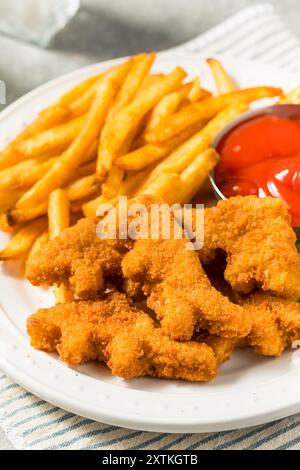 Gesunde Kinder Dinosaurier Chicken Nuggets mit Pommes und Ketchup Stockfoto