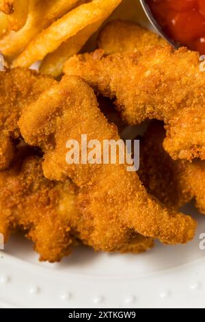 Gesunde Kinder Dinosaurier Chicken Nuggets mit Pommes und Ketchup Stockfoto