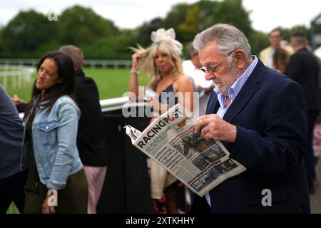 Ein Rennfahrer liest die Racing Post während der Racing League auf der Royal Windsor Racecourse in Windsor. Bilddatum: Donnerstag, 15. August 2024. Stockfoto