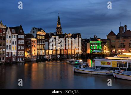 AMSTERDAM, NIEDERLANDE - 12. APRIL 2024 . Nächtlicher Blick auf den Amsterdamer Kanal mit niederländischen Häusern. Nächtlicher Blick auf den Amsterdamer Kanal, typisch holländisches Haus Stockfoto