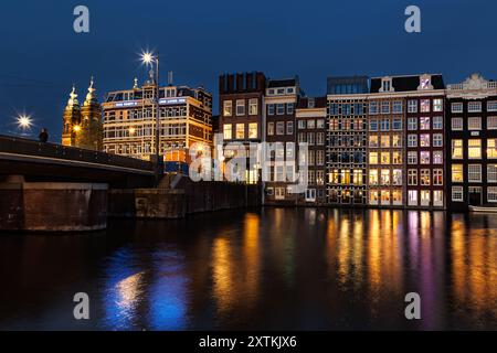 AMSTERDAM, NIEDERLANDE - 12. APRIL 2024 . Nächtlicher Blick auf den Amsterdamer Kanal mit niederländischen Häusern. Nächtlicher Blick auf den Amsterdamer Kanal, typisch holländisches Haus Stockfoto