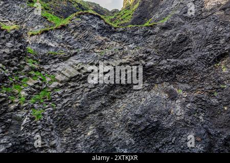 Halsanefshellir Höhle aus Basaltsäulen am Reynisfjara Black Sand Beach, vulkanische Felsformationen bedeckt mit Moos, Island. Stockfoto