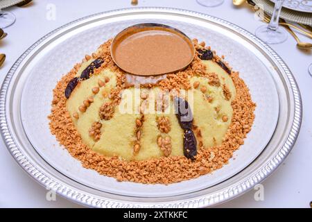 Couscous ist ein köstliches Gericht aus dem Maghreb, das aus kleinen gedämpften Bällchen aus gemahlenem Hartweizengriß besteht, begleitet von Datteln, Feigen, Mandel und Trauben Stockfoto