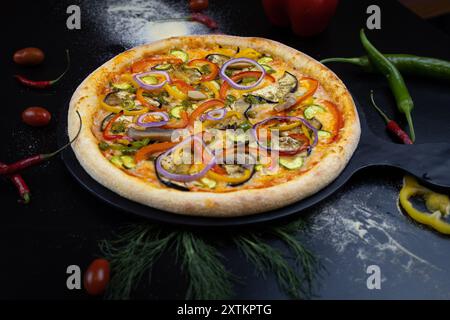 Pizza mit Gemüse und Pilzen auf schwarzem Hintergrund Stockfoto