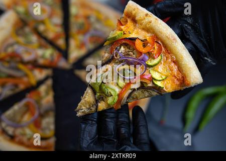 Pizza mit Gemüse und Pilzen auf schwarzem Hintergrund Stockfoto