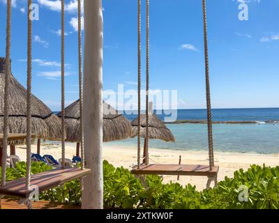 Entdecken Sie Ihr eigenes Stück Paradies an der Riviera Maya. Genießen Sie die Ruhe, während Sie sich in einer Hängematte in dieser bezaubernden Strandbar entspannen Stockfoto