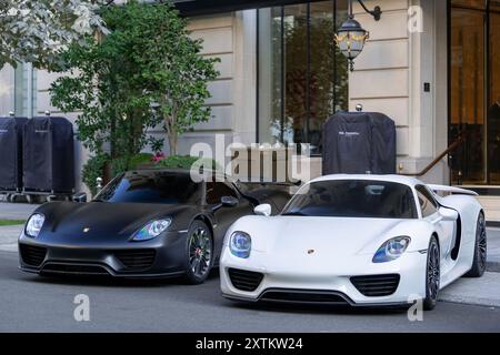 Paris, Frankreich - Blick auf zwei Porsche 918 Spyder, die auf einer Pariser Straße vor einem Palast geparkt sind. Stockfoto