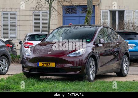 Nancy, Frankreich - Blick auf ein burgunderrotes Tesla Model Y auf einem Parkplatz. Stockfoto