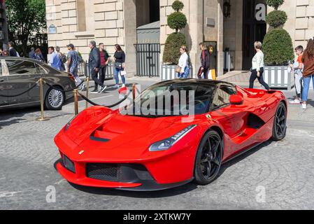 Paris, Frankreich - Blick auf einen roten Ferrari LaFerrari, der auf einer Pariser Straße vor einem Palast geparkt ist. Stockfoto