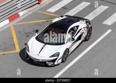 Monte Carlo, Monaco - Blick auf einen weißen McLaren 720S, der auf der Straße in der Fairmont Haarnadelkurve fährt. Stockfoto