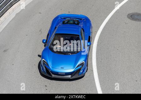 Monte Carlo, Monaco - Blick auf einen blauen McLaren 675LT Spider, der auf der Straße in der Fairmont Haarnadelkurve fährt. Stockfoto