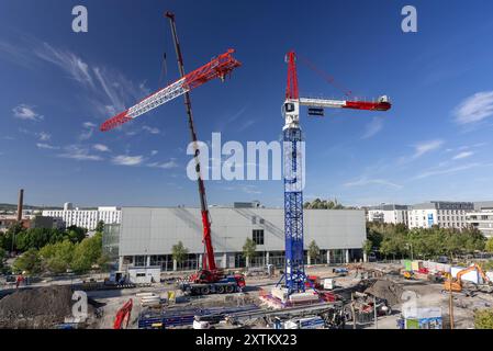 Nancy - Blick auf einen roten Mobilkran Liebherr montiert einen Liebherr-Turmkran auf einer Baustelle für den Bau eines Wohngebäudes. Stockfoto