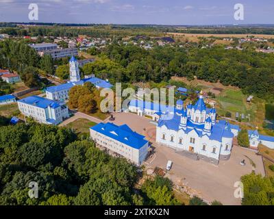 Das farbenfrohe Foto von Korennaja Pustyn in der Region Kursk, Russland, einer wunderschönen orthodoxen Kirche mit dem grünen Wald und Panoramablick. Stockfoto