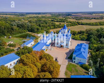 Das farbenfrohe Foto von Korennaja Pustyn in der Region Kursk, Russland, einer wunderschönen orthodoxen Kirche mit dem grünen Wald und Panoramablick. Stockfoto