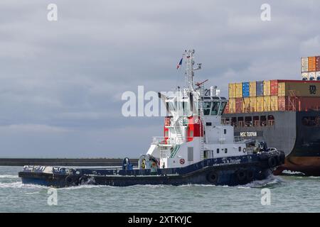 Le Havre, Frankreich - Blick auf den Hafenschlepper VB FECAMP, der ein Containerschiff begleitet, das den Hafen von Le Havre verlässt. Stockfoto