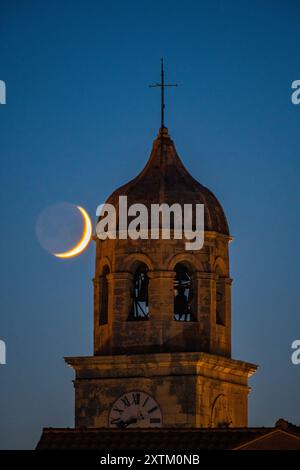 Abenddämmerung in Cavtat, Kroatien - wenn die Sonne untergeht, steigt der Mond auf, mit der Nikolaikirche im Vordergrund Stockfoto