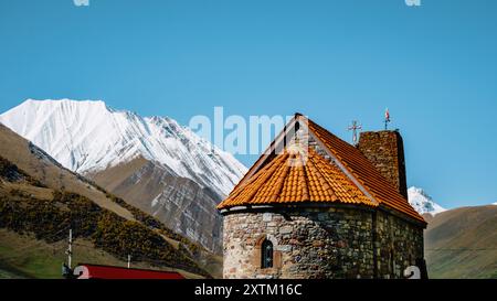 Die Kirche des Klosters Abano mit schneebedeckten Bergen im Hintergrund in der Truso-Schlucht bei Kazbegi in Georgien Stockfoto