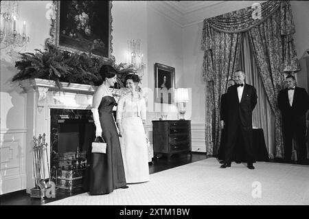 Lady Bird Johnson und Prinzessin Margaret von Großbritannien posieren vor dem Kamin, US-Präsident Lyndon Johnson und Antony Armstrong Jones (teilweise hinter Johnson verdeckt) schauen zu, Queen's Room, Weißes Haus, Washington, D.C. USA, Yoichi Okamoto, 17. November 1965 Stockfoto