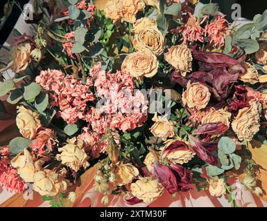 Wunderschöner Blumenstrauß mit trockenen, beigen Rosen. Zusammensetzung mit getrockneten Rosen in anderen Blüten. Knospen mit cremefarbenen Rosenblüten, in sanfter Farbe. Blumen Stockfoto