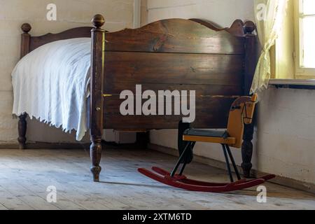 Altes Bett im Schlafzimmer mit Schaukelpferd Stockfoto