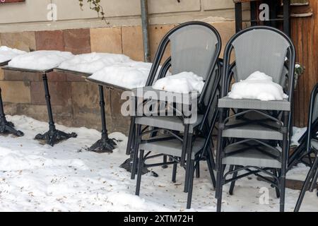 Schneebedeckte Tische und Stühle auf der Straße Stockfoto