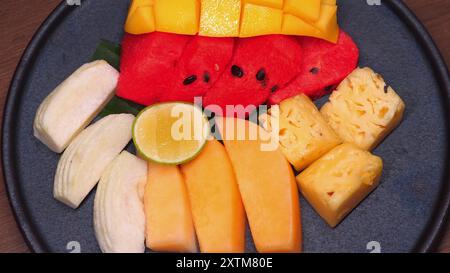 Verschiedene tropische Früchte, ordentlich angeordnet auf runder Platte, mit Stockfoto