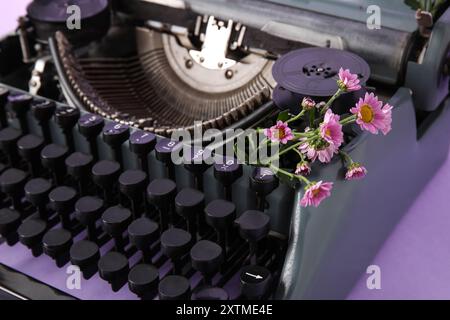 Vintage-Schreibmaschine auf lilafarbenem Hintergrund, Nahaufnahme Stockfoto