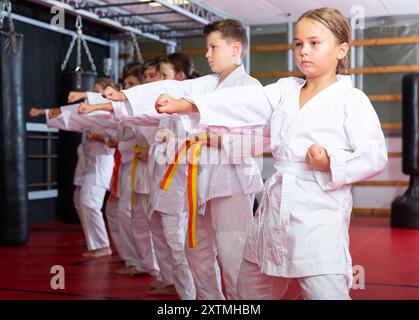 Karate Kids im Kimono, die Kata Moves ausführen Stockfoto