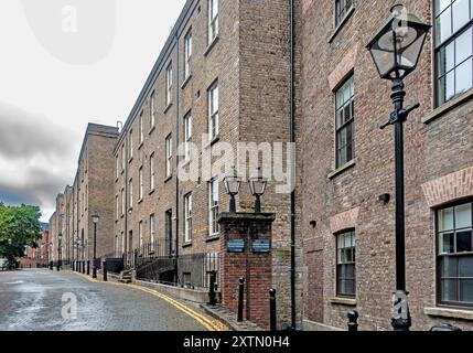 Alte historische Backsteingebäude in Dublin Castle, Dublin, Irland, stehen an einer ruhigen Straße, mit Straßenlaternen, die den Weg beleuchten. Stockfoto